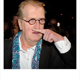Gerrit Komrij (dichter) maakt een snor - verwijzing naar de zojuist gearriveerde Kader Abdolah (auteur boekenweekgeschenk).