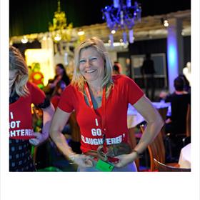 Dominique Vijfwinkel (Tomey en Verstegen, Culemborg) trekt voor Karin Slaughter (misdaadauteur) het feestshirt aan - net als de rest van de zaal­.