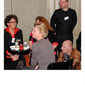 Nelleke Geel (in rood overhemd), Tino Köhler (in zwart shirt), Adriaan Krabbendam (vertaler, zittend)