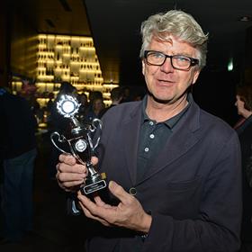 Nog even zelf vasthouden: Hans Robertus (vormgever, jurylid) met de beker die hij straks gaat geven aan de maker van het best vormgegeven boek.