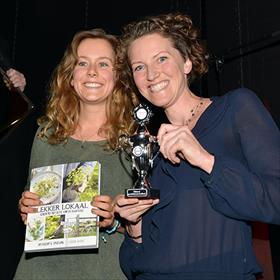 Elisabeth Lanz (voorzitter Youth Food Movement) toont &#39;Lekker Lokaal&#39; van Jobien Groen (met beker), die zojuist de prijs in de categorie Duurzaam heeft gewonnen.