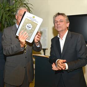 Er is door de gasten &#160;€ 2.500 bijeengebracht. Hiervan gaat Stichting Dedicon een boek van Jan Paul Schutten uitgeven in grote (Jumbo) letters, voor&#160;slechtziende kinderen.&#160;Rechts&#160;Koen Krikhaar (stichting Dedicon).