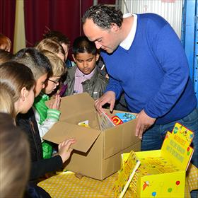 Guido Paulsen (vrijwilliger Stichting Jarige Job) laat zien wat er in een feestdoos gaat.