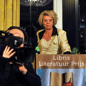 Na het toetje betreedt de pers de zaal. Achter het spreekgestoelte Margot Dijkgraaf (bestuurslid van de Stichting Libris Literatuur Prijs)