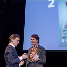 Bram Kleiweg (De Arbeiderspers) neemt de oorkonde in ontvangst voor het op één na bestverkochte boek van 2019: Pfeijffers 'Grand Hotel Europa'. En geeft Eveline Aendekerk een cadeautje: het belletje van de piccolo