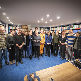 Groepsfoto van Angela Merkel met het team van De Arbeiderspers en Athenaeum Boekhandel.