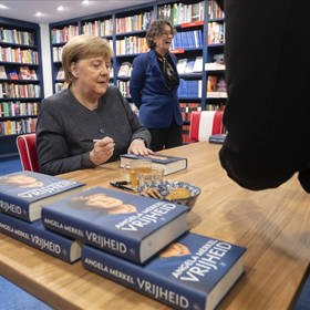 Angela Merkel tijdens het signeren.