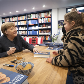 Angela Merkel tijdens het signeren.