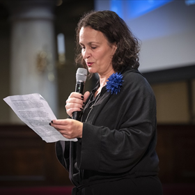 Elik Lettinga, uitgever bij De Arbeiderspers, verwelkomt iedereen in het Duits in de Oude Lutherse Kerk voorafgaand aan het gesprek tussen Arnon Grunberg en Angela Merkel.