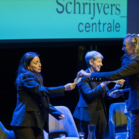 Johanna Somers reikt de 'wie leest heeft een goed verhaal'-pin uit