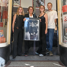 Loerts met een foto van oprichter Johan Polak. Links Lola Storm, rechts Roel Salemink