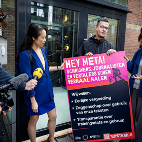 Overhandiging petitie aan een bewaker van het kantoorpand waar Meta is gevestigd. Rechts Anja Sicking van de werkgroep Literaire Auteurs (foto Ramon van Flymen)